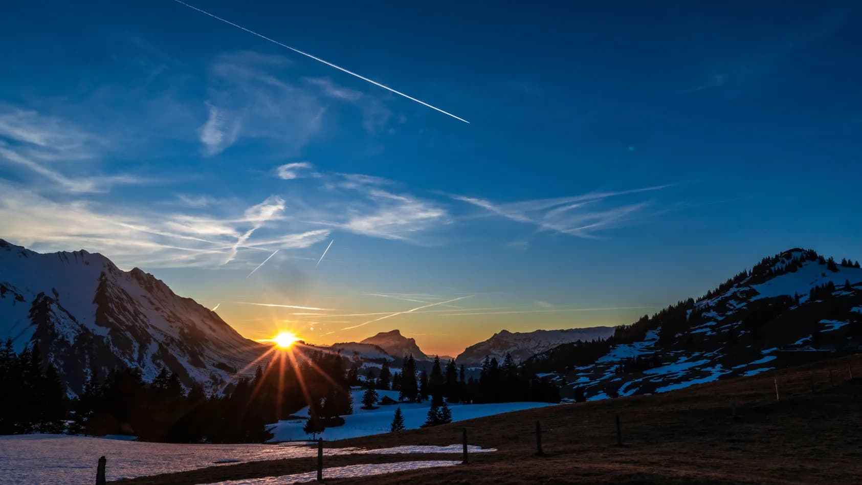 Zonsopkomst boven besneeuwde bergen